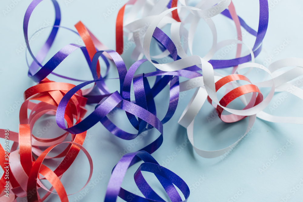 Bright streamers on blue background, festive decor Bright streamers on blue background, festive decor