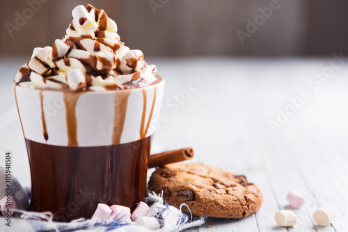 Messy hot chocolate, cream and marshmallows and a choc-chip cookie