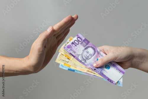 Hand holding giving cash banknotes Philippines peso paying bills, payment procedure or bribe, salary photo
