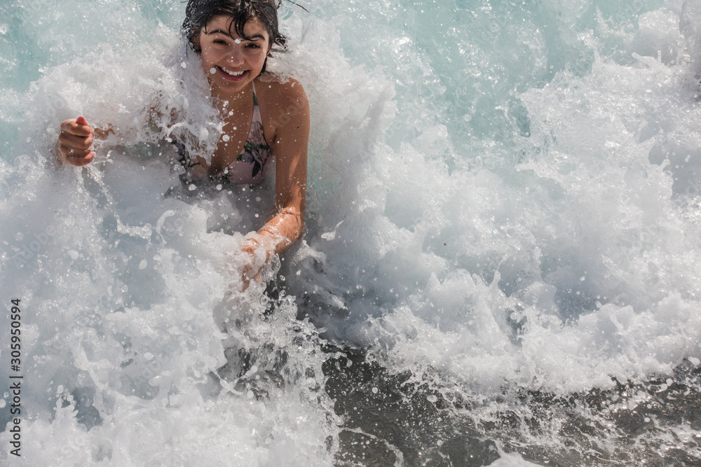 Girl enjoying the wave splashes at the beach