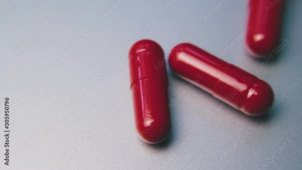 motion along row of bright red medical capsules lying on clean white background extreme close view motion along row of bright red medical capsules lying on clean white background extreme close view