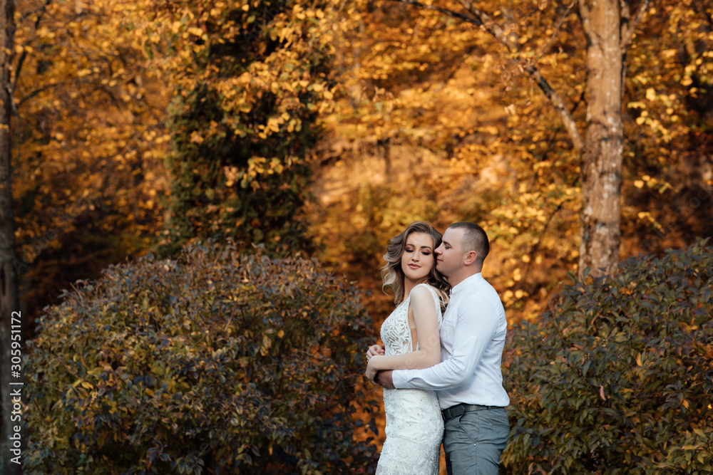 Autumn love story of a young couple. The guy and the girl are hugging. Young people love each other. Autumn walk. Young happy couple on a walk in the park Autumn love story of a young couple. The guy and the girl are hugging. Young people love each other. Autumn walk. Young happy couple on a walk in the park