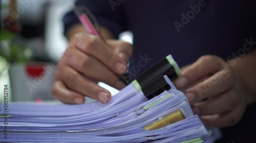 Businessman hands working in stacks documents of paper files, searching information on desk office, Accounting budget report file, check working for arranging unfinished of paperwork on busy office