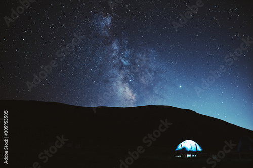 Illuminated camping tent under stars at night. nature reserve Sochi