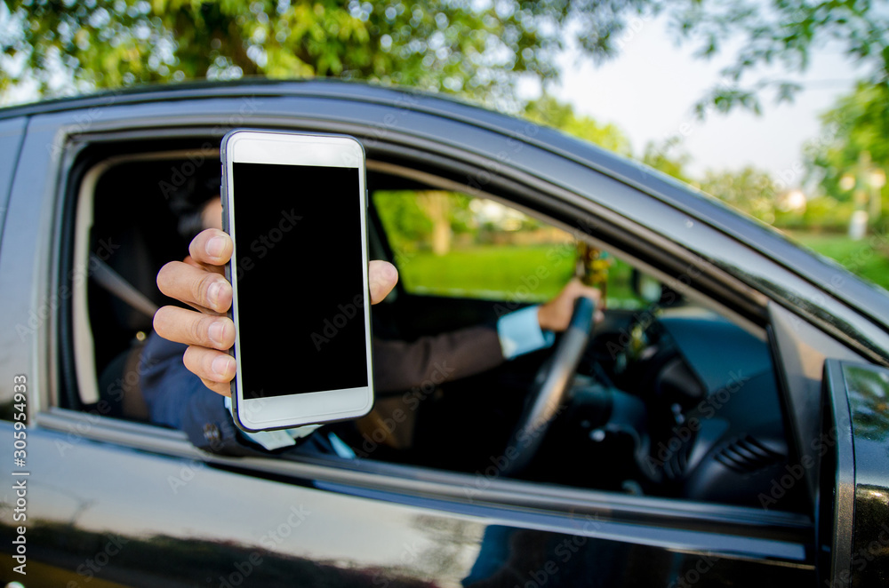 Young businessman lifted their smartphone in the car.