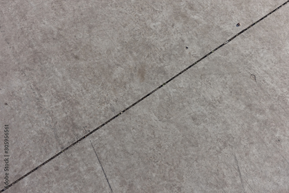 Fototapeta premium Diagonal joint between two light grey concrete slabs