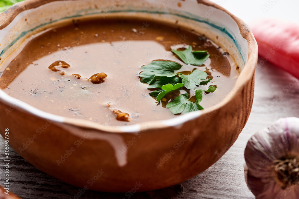 Close up view of soup kharcho with cilantro and garlic on table Close up view of soup kharcho with cilantro and garlic on table