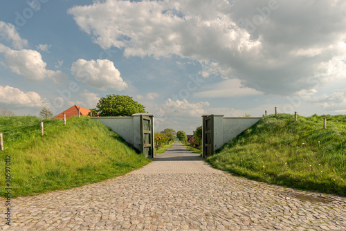 View of a street through an open flood barrier in a sea dyke