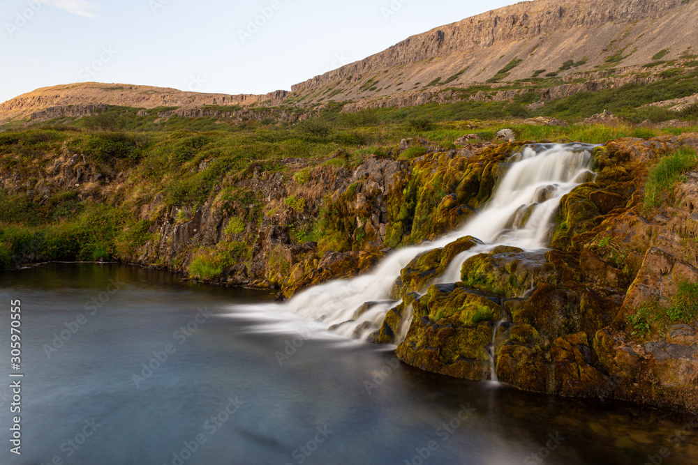 Fotografie Waterfall on the mountain river falling into a lake