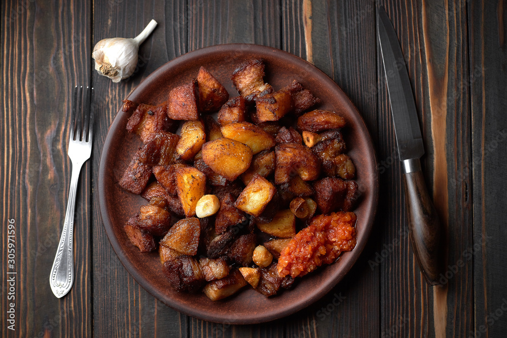 Homemade potato with meat, garlic, adjika, on wooden background Homemade potato with meat, garlic, adjika, on wooden background