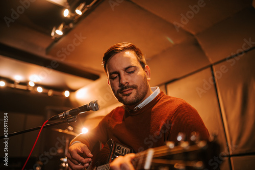 Close-up portrait of a man enjoy playing guitar.