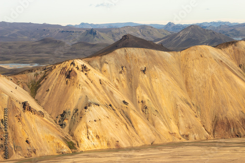 Yellow and black mountains in loaf shape looking like desert dunes