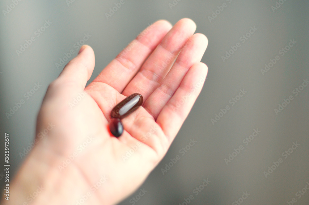 two medicine capsules are in the palm of your hand