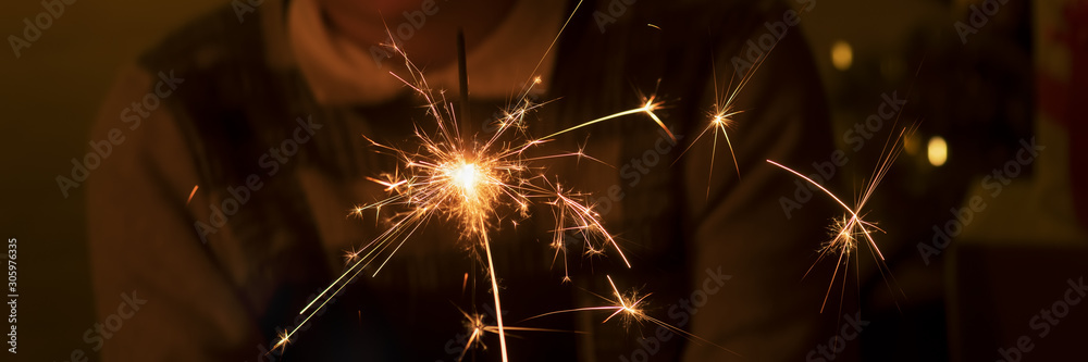 Obraz premium Bengal fire and sparks macro photo festive bokeh background Christmas and New Year