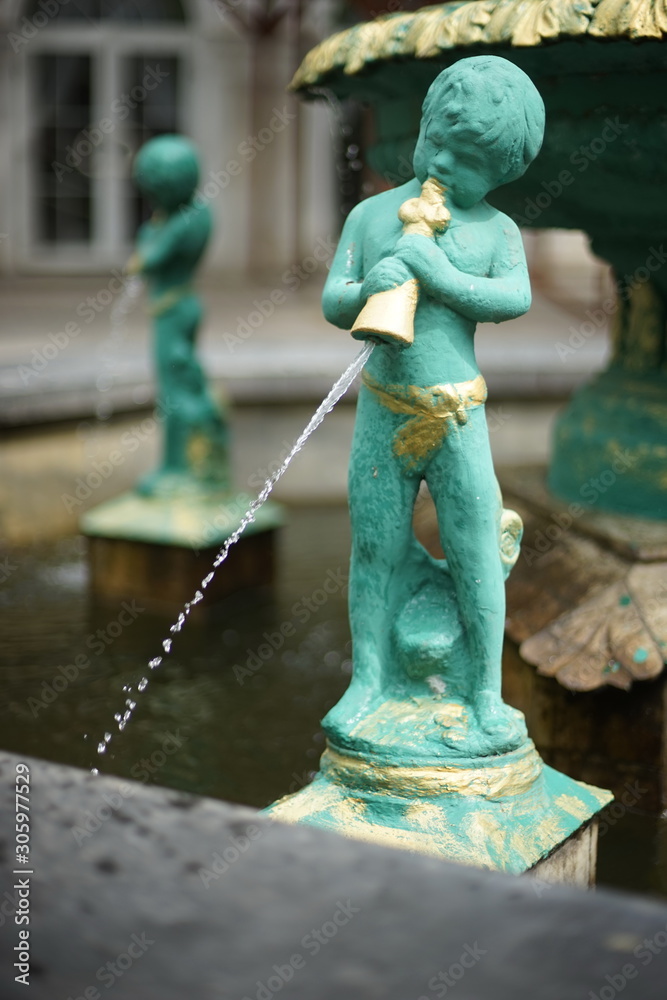 Fountain with boys pours water from the vessel. Cupid statue. Fountain with boys pours water from the vessel. Cupid statue.