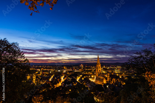 Germany, Famous black forest city freiburg im breisgau in baden, skyline with cathedral after sunset in magical dawning atmosphere from above roofs