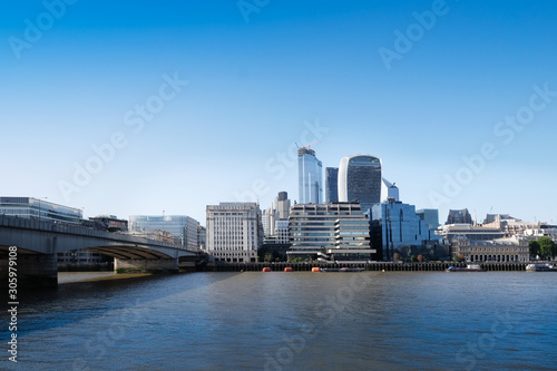 City of London, United Kingdom 6th July 2019: London skyline seen from south bank, river Thames in foreground on summer day