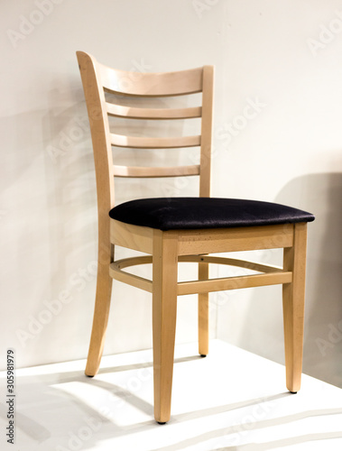 Traditional wooden chair with soft textile seat standing on white pedestal