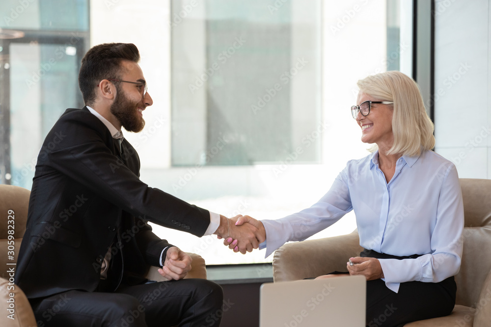Smiling diverse multiethnic colleagues handshake closing deal Smiling diverse multiethnic colleagues handshake closing deal
