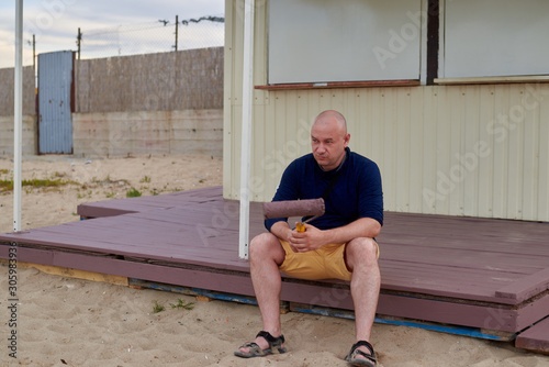 man on a painted porch with a roller in his hand photo