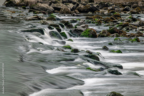 Long exposure as the River Meavy flows over rocks at Lopwell Weir, Plymouth, Devon photo