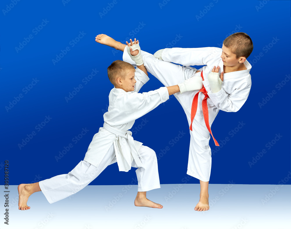 Children in karategi are training karate blows