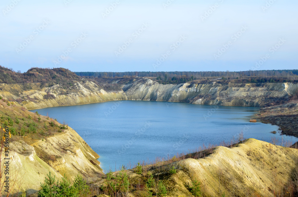 Artificial lake was is formed after the extraction of chalk in an industrial quarry at Krasnoselsky village in the Belarus. Water in open pit between the mountains. Belarusian Maldives Artificial lake was is formed after the extraction of chalk in an industrial quarry at Krasnoselsky village in the Belarus. Water in open pit between the mountains. Belarusian Maldives