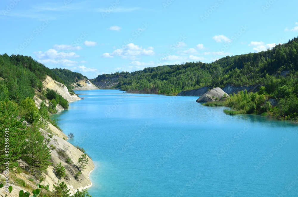 Artificial lake was is formed after the extraction of chalk in an industrial quarry at Krasnoselsky village in the Belarus. Turquoise background of the clear ocean water  in summer tropical season.