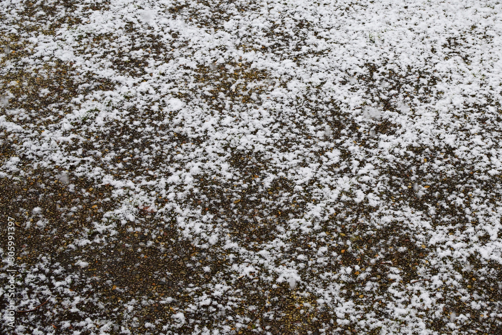 First snow. The snowy surface of the courtyard tiles. Background, texture
