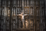 Jesus Christ on the cross in a cathedral or church interior surrounded by ornate stone carvings