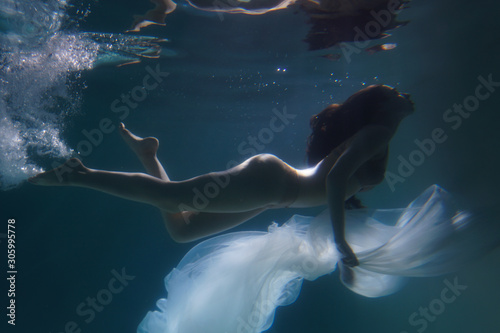 Fotografiet Beautiful girl swims underwater with long hair