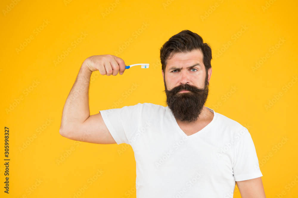 Mint paste. Healthy teeth. On guard of freshness. Teeth whitening procedure. Bearded man hold toothbrush yellow background. Hipster serious strict face cares hygiene. Brush teeth. Fresh breathe Mint paste. Healthy teeth. On guard of freshness. Teeth whitening procedure. Bearded man hold toothbrush yellow background. Hipster serious strict face cares hygiene. Brush teeth. Fresh breathe
