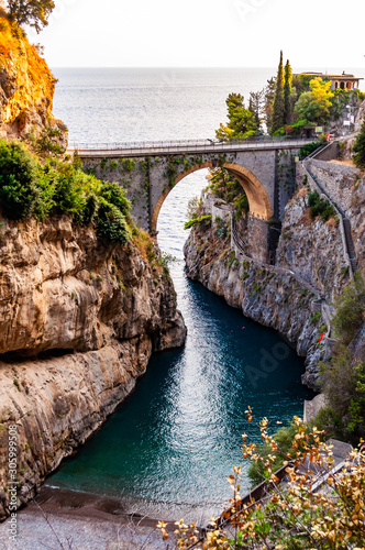 View on Fiordo di Furore arc bridge built between high rocky cliffs above the Tyrrhenian sea bay in Campania region. Unique cove under the cliffs, natural gorge, canyon or fiord