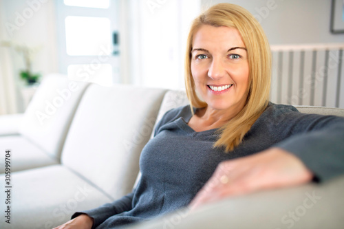 Relaxed woman enjoying rest on comfortable sofa, calm attractive girl relaxing on couch