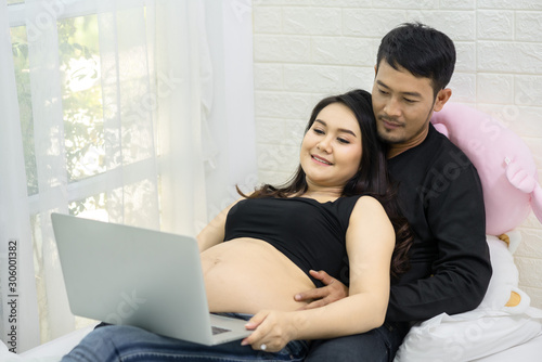 Pregnant woman is watching movies online with her boyfriend on the weekend.