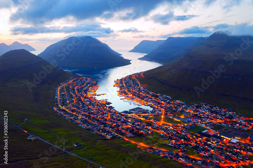 Fantastic aerial evening cityscape of Klaksvik town with glowing streets and fjord, Bordoy island, Faroe islands, Denmark. Landscape photography photo