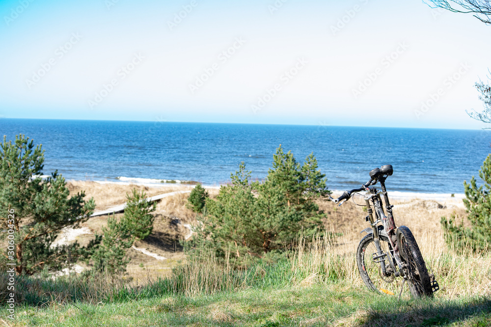 bicycle standing on dunes by the sea shore with view to the Baltic sea