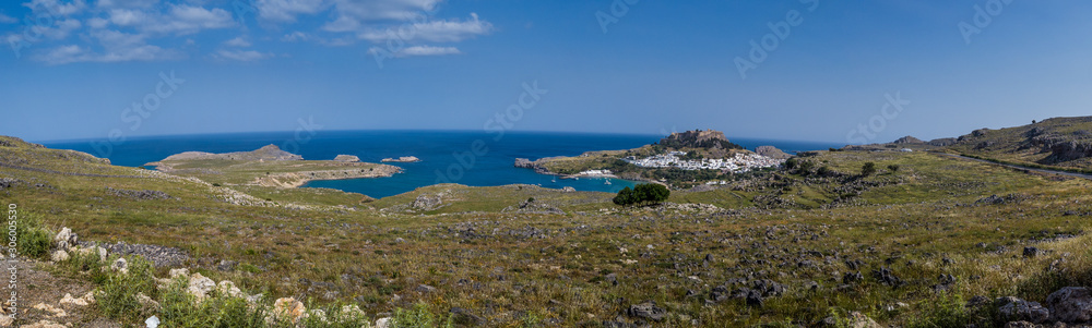 Lindos on the rocky shore of the blue sea on a sunny summer day. St. Paul's Bay on Rhodes Greece Europe.