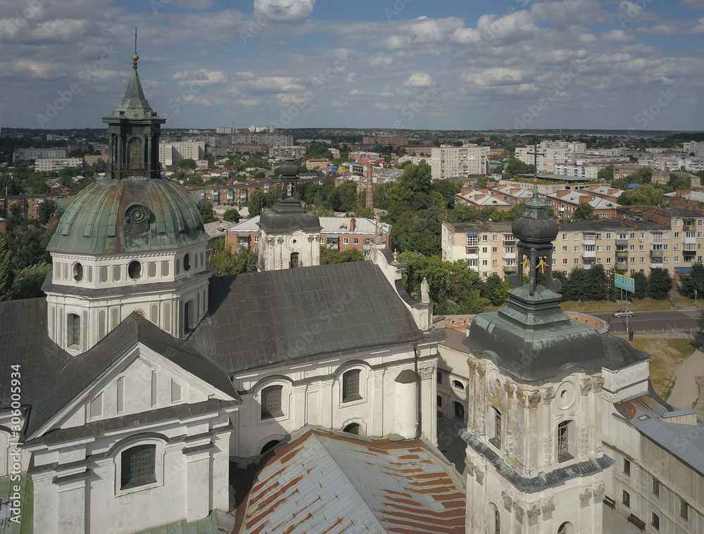 Obraz premium Berdychiv, Ukraine - 7 7 2019: Roman Catholic Church of the Assumption of the Blessed Virgin Mary. Aerial photography of the monastery with defense walls. Baroque architecture in a modern city