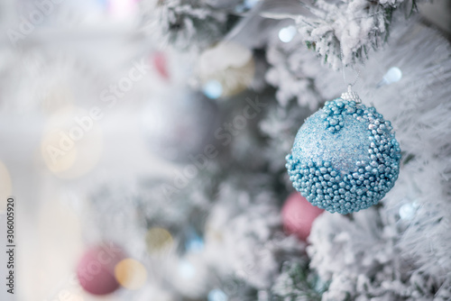 New Year blue and turquoise fur-tree decoration with balls and bowknots, ribbons, flowers on pink lights background