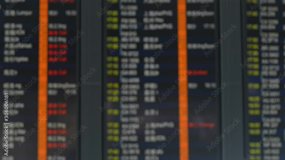 Unrecognizable Blurred view of scoreboard hanging in interior of international airport in chinese city. Big display with changing flight status for customers of modern terminal. Timetable for Unrecognizable Blurred view of scoreboard hanging in interior of international airport in chinese city. Big display with changing flight status for customers of modern terminal. Timetable for