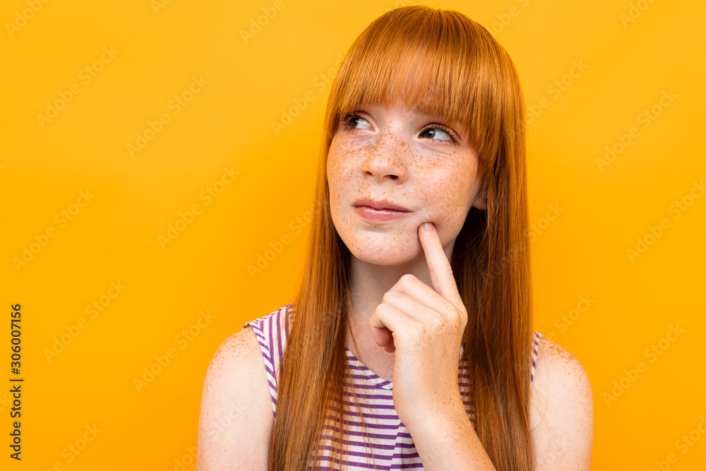 close-up portrait of a of a pensive red-haired girl on a yellow background close-up portrait of a of a pensive red-haired girl on a yellow background