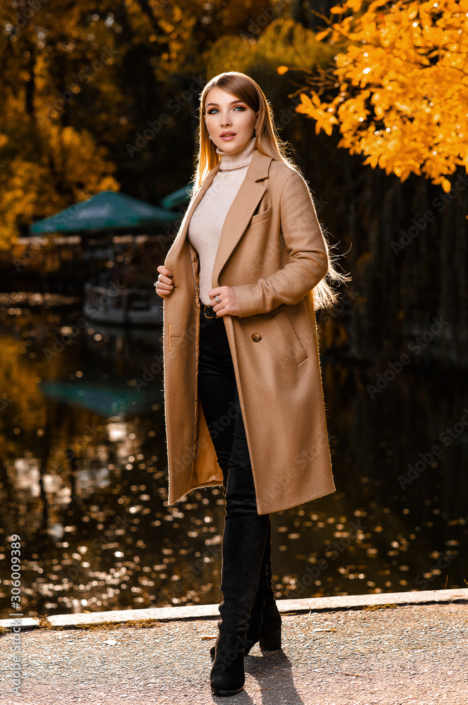 A beautiful blonde in a beige coat walks in the autumn in the park. Yellow leaves, autumn, nature. Autumn photo shoot in the forest A beautiful blonde in a beige coat walks in the autumn in the park. Yellow leaves, autumn, nature. Autumn photo shoot in the forest