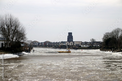 ice floes on the river Hollandsche IJssel at the town of Moordrecht in The Netherlands. Th ferry keeps on service between Gouderak and Moordrecht photo