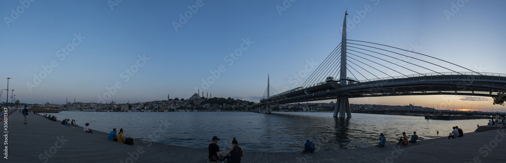 Fototapeta premium Istanbul, Turkey, Middle East: a breathtaking sunset with panoramic view of the skyline of the city and the Ataturk Bridge, highway bridge on the Golden Horn, seen from the public park along the water