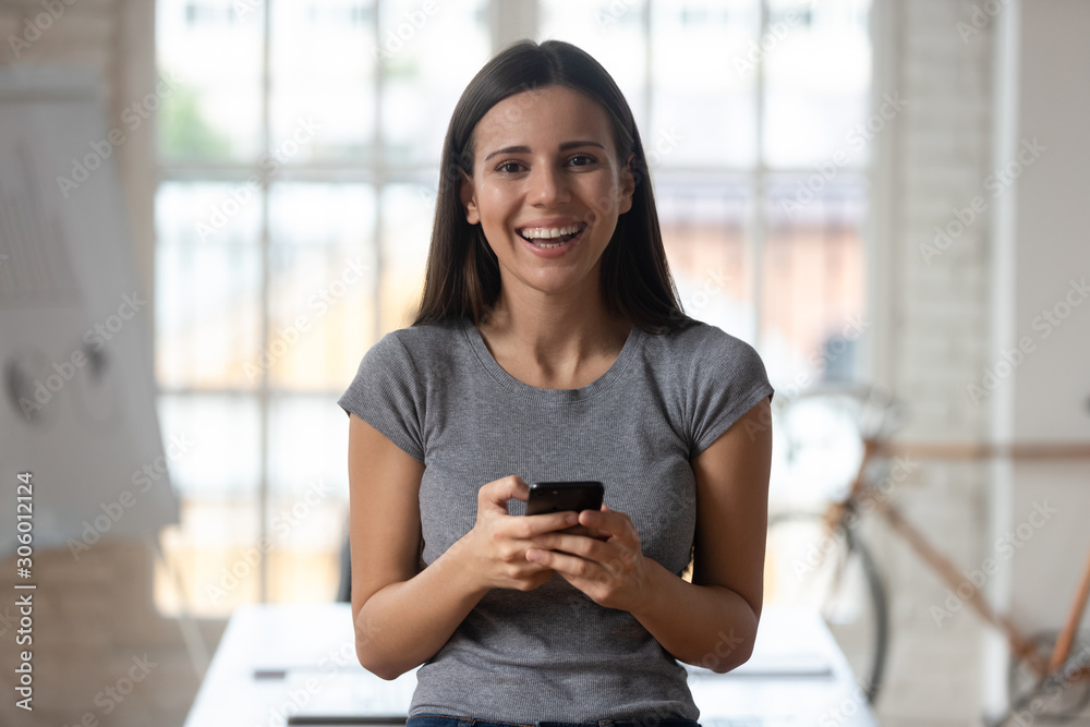 Happy laughing millennial company worker holding smartphone. Happy laughing millennial company worker holding smartphone.