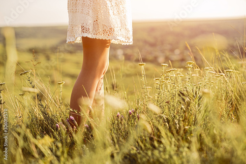 Crop female standing in field on summer day