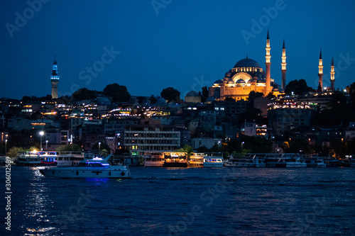 Istanbul, Turkey, Middle East: night skyline of the city with view of boats in the Golden Horn and the illuminated Suleymaniye mosque, Ottoman imperial mosque commissioned by Suleiman the Magnificent 