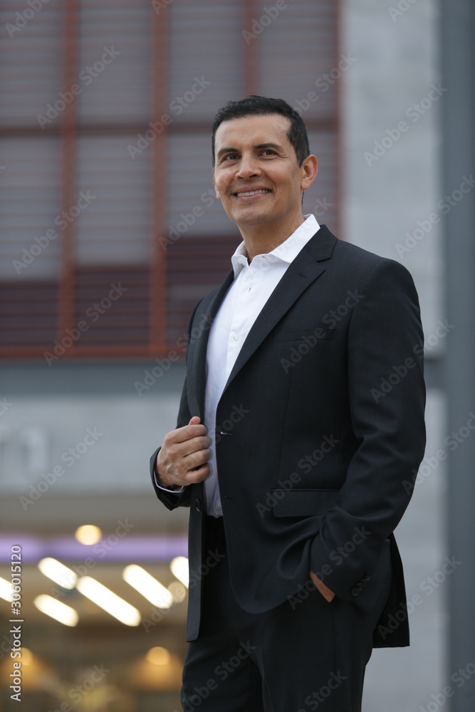 Handsome Latino executive man leaving office, talking on the phone and  wearing casimir suit Stock Photo | Adobe Stock