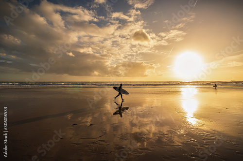 Surfer on the beach at sunset, Caravelos beach, Portugal